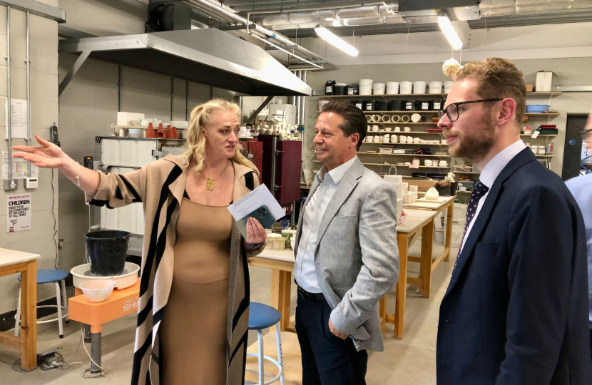Hannah Shows Jack and Minister Huddleston around a room in the factory